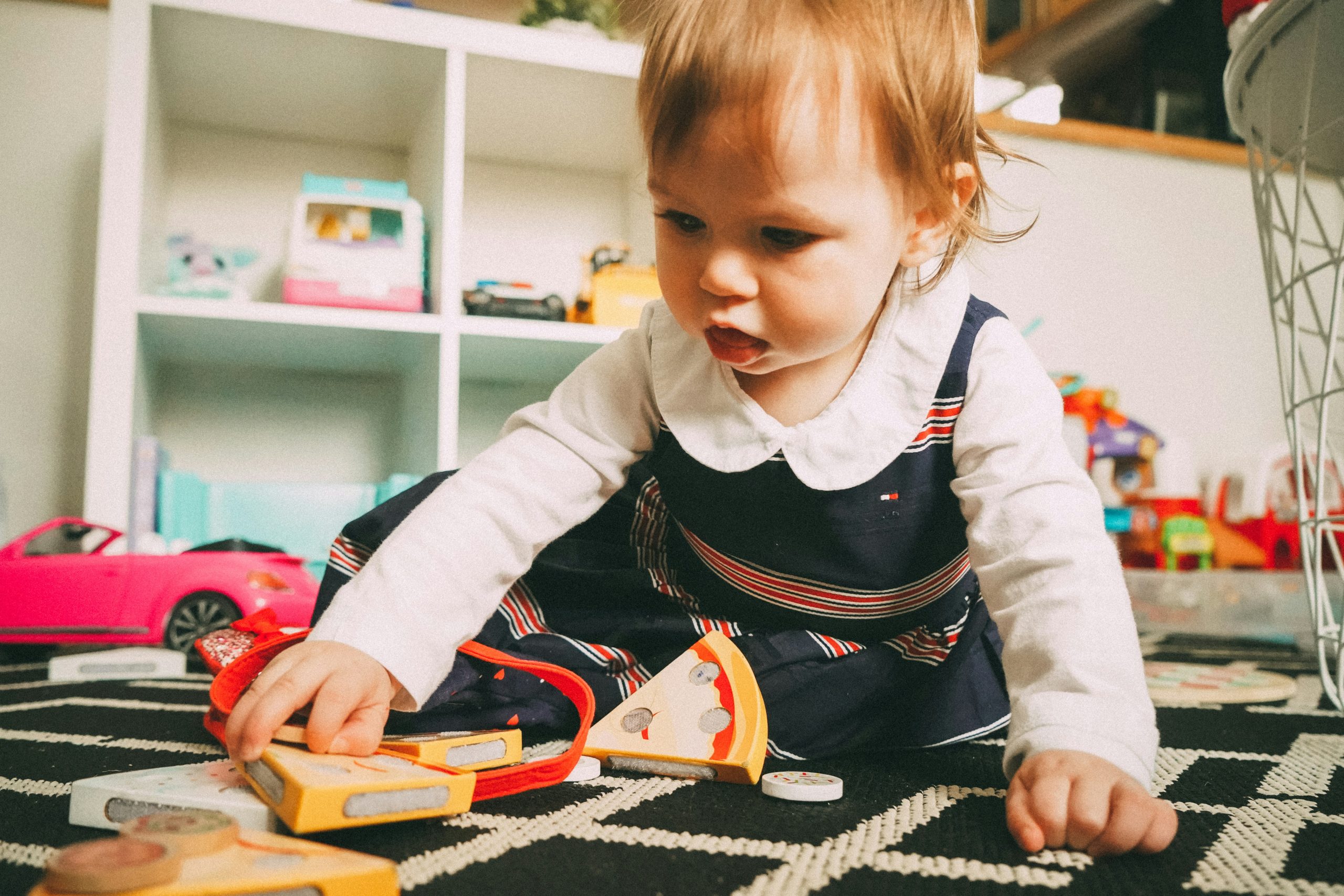 Baby playing with toys on the carpet in a daycare